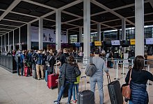 Reisende am Flughafen - Foto: Paul Zinken/dpa