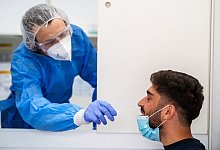 Viktor Dietrich (l) nimmt einen Nasenabstrich von Marwied Hakimi, Leiter der Teststation in Frankfurt/Main. - Andreas Arnold/dpa