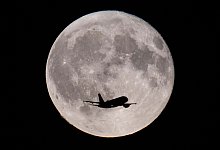 Flugzeug vor dem Vollmond - Boris Roessler/dpa
