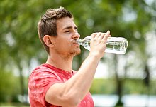 Mann trinkt aus einer Wasserflasche - Tobias Hase/dpa-tmn