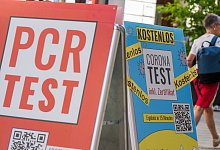 PCR-Tests werden am Eingang einer Apotheke in der M&uuml;nchner Innenstadt beworben. - Peter Kneffel/dpa