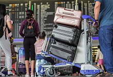 Reisende warten auf ihren Abflug - Foto: Frank Rumpenhorst/dpa/dpa-tmn