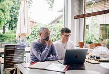Zwei Personen sitzen an einem Laptop - Zacharie Scheurer/dpa-tmn/dpa