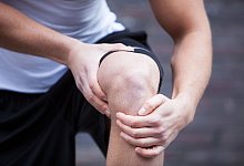 Ein Mann h&auml;lt sich das Kniegelenk - Christin Klose/dpa-tmn/dpa