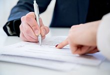 Ein Mann unterzeichnet einen Vertrag - Christin Klose/dpa-tmn