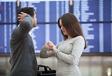 Ein Paar vor einer Anzeigetafel am Flughafen - Christin Klose/dpa-tmn