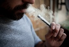 Ein Mann verwendet eine E-Zigarette - Fabian Strauch/dpa/dpa-tmn