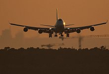 Eine Boeing 747 landet im letzten Licht des Tages auf dem Flughafen Frankfurt. - Boris Roessler/dpa