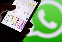 Smartphone mit Emojis aus WhatsApp vor dem WhatsApp-Logo - Fabian Sommer/dpa/dpa-tmn