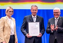 Bundespr&auml;sident a.D. Christian Wulff (M) erh&auml;lt aus den H&auml;nden von Oberb&uuml;rgermeisterin Katharina P&ouml;tter die Ehrenb&uuml;rgerw&uuml;rde der Stadt Osnabr&uuml;ck. Bundespr&auml;sident Frank-Walter Steinmeier applaudiert. - David Inderlied/dpa