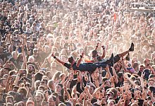 Ein Mann beim Crowdsurfen auf einem Festival - Daniel Reinhardt/dpa/dpa-tmn