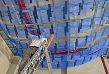 Mitarbeiter installiert an der Zimmerdecke Kapillarrohr-Matten - Patrick Pleul/dpa/dpa-tmn