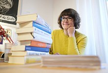 Lisa K&ouml;geb&ouml;hn vor einem B&uuml;cherstapel - Sebastian Willnow/dpa-tmn