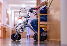 Bewohner sitzt mit seinem Rollator auf dem Flur eines Pflegeheims - Jens B&uuml;ttner/dpa/dpa-tmn