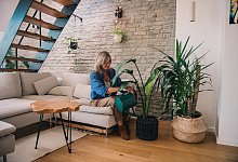 Frau gie&szlig;t die Zimmerpflanzen in einer Wohnung - Zacharie Scheurer/dpa-tmn