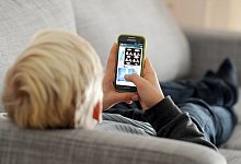 Kind mit Smartphone - Foto: Tobias Hase/dpa