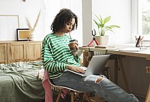Teenage girl using laptop and drinking hot chocolate at home - 1 - Alena Kuznetsova/picture alliance/Westend61