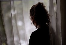 Eine Frau steht am Fenster - Fabian Sommer/dpa/dpa-tmn