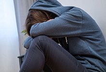 Traurige Frau sitzt am Boden - Christin Klose/dpa-tmn