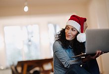 Eine Frau mit Weihnachtsmütze am Laptop - Joseffson/Westend61/dpa-tmn