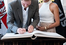 Prinz Harry, der Herzog von Sussex, und seine Frau Meghan, Herzogin von Sussex, tragen sich in das goldene Buch der Stadt D&uuml;sseldorf ein. - Fabian Strauch/dpa