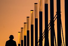 Ein Mann mit Kopfhörern bei Sonnenaufgang - Julian Stratenschulte/dpa/dpa-tmn