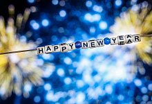 Der Schriftzug "Happy New Year" vor einem Feuerwerk - Christoph Reichwein/dpa