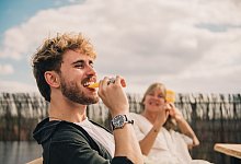 Ein junger Mann isst ein Wassereis am Stiel - Zacharie Scheurer/dpa-tmn