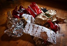 Geschenkpapier liegt nach der Bescherung auf dem Boden - Karl-Josef Hildenbrand/dpa/dpa-tmn
