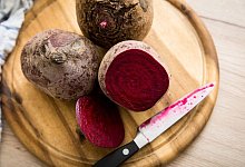 Eine Rote Bete liegt aufgeschnitten auf einem Brettchen - Christin Klose/dpa-tmn