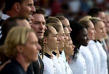 Bundestrainerin Martina Voss-Tecklenburg und die deutschen Spielerinnen singen bei der EM die Nationalhymne. - Sebastian Christoph Gollnow/dpa