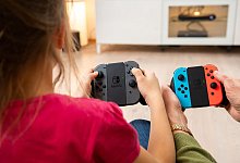 Spielende halten bunte Controller in der Hand - Benjamin Nolte/dpa/dpa-tmn