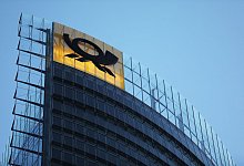 Das Logo der Post am Post-Tower, dem Unternehmenssitz der Deutsche Post DHL Group in Bonn. - Oliver Berg/dpa