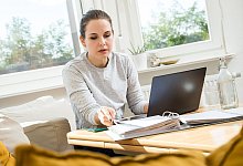 Eine Frau sitzt am Schreibtisch - Christin Klose/dpa-tmn