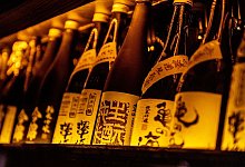 Sakeflaschen aneinandergereiht. - Zacharie Scheurer/dpa-tmn