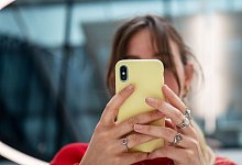 Eine Frau schaut auf ihr Smartphone - Bernd Diekjobst/dpa-tmn