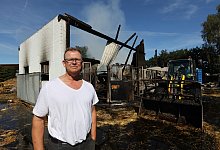 Andreas Kollmeyer steht vor den Resten seines kleineren Reitstalls. Dort starben in der Nacht zu Freitag sieben Tiere in den Flammen. - Nicole Sielermann