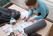 Eine Frau packt einen Notfallrucksack - Christin Klose/dpa-tmn