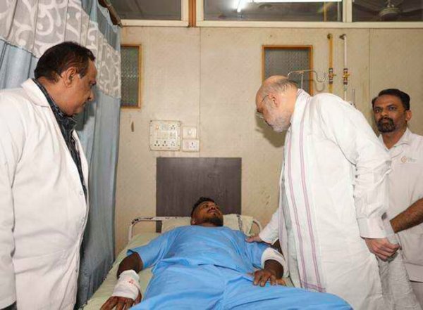 Das vom indischen Innenministerium herausgegebene Foto zeigt Innenminister Amit Shah bei einem Treffen mit dem Überlebenden des britischen Flugzeugabsturzes, Vishwash Kumar Ramesh, in einem Krankenhaus in Ahmedabad. - © Indian Ministry of Home Affairs/dpa