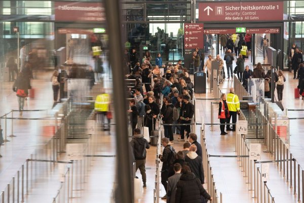 Reisende während des bundesweiten Warnstreiks an den Kontrollstellen im Flughafen BER. - © Paul Zinken/dpa