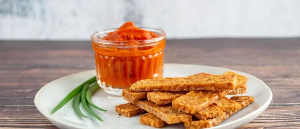 Durch Edelschimmel wachsen Sojabohnen zusammen und werden als Tempeh schnittfest. Es schmeckt würzig, lässt sich geschnitten knusprig braten oder frittieren und wie Chips essen. - © smarticular Verlag/dpa-tmn