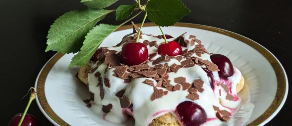 Auf die mit Espresso getränkten Löffelbiskuits kommen eine Quark-Sahne-Masse und reichlich Kirschen. Das Tiramisu wird mit Schokoraspeln getoppt. - © Doreen Hassek/hauptstadtkueche.blogspot.com/dpa-tmn