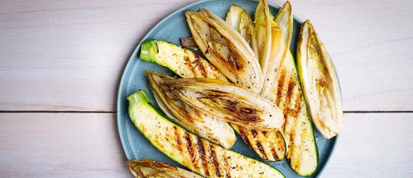 Die länglich geschnittenen Zucchini- und Chicorée-Streifen werden mit einer Marinade aus Olivenöl, Limettensaft, Salz und Pfeffer eingepinselt, dann auf jeder Seite 2–3 Minuten gegrillt. - © Ariane Bille/BVEO/dpa-tmn