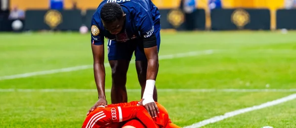 Jamal Musiala liegt mit starken Schmerzen verletzt am Boden. PSG-Profi William Pacho kümmert sich um ihn. - © Malachi Gabriel/ZUMA Press Wire/dpa