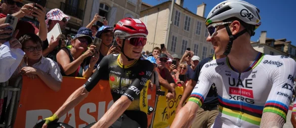 Der Däne Jonas Vingegaard (l) und der Slowene Tadej Pogacar (r) unterhalten sich vor dem Start. - © Thibault Camus/AP/dpa