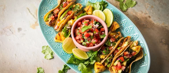 Richtig stilecht werden Hähnchen-Tacos erst mit Zugaben wie der mexikanische Tomatensalsa «Pico de Gallo», argentinischer Kräutersauce «Chimichurri», Avocado, gegrillter Ananas, Koriander und Limetten. - © Christin Klose/dpa-tmn