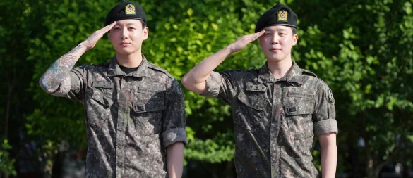 Die Mitglieder der K-Pop-Band BTS, Jimin (r) und Jung Kook, salutieren nach ihrer Entlassung aus dem Militärdienst. - © Lee Jin-man/AP/dpa
