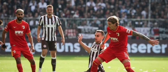 Im Zweikampf: Kristijan Jaki? vom FC Augsburg (r) und St. Paulis James Sands. - © Christian Charisius/dpa