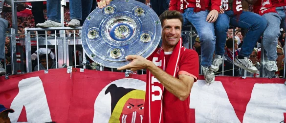 Thomas Müller zeigt die Meisterschale. - © Tom Weller/dpa
