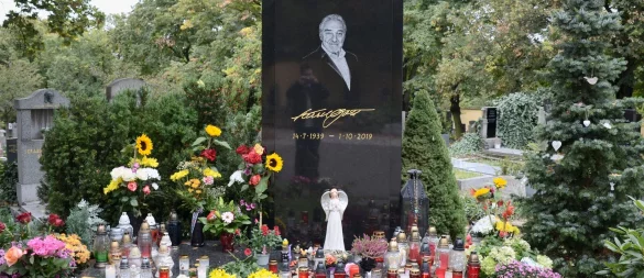 Am Grab des tschechischen Sängers Karel Gott auf dem Malvazinky-Friedhof stehen frische Blumen und brennende Kerzen. (Archivbild) - © Michael Heitmann/dpa